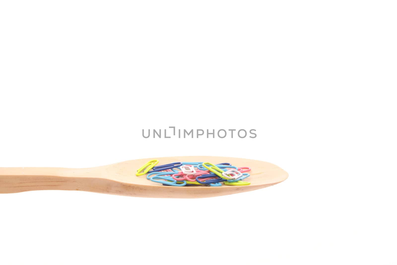 paperclips simply offered on a wooden spoon isolated on a white background 