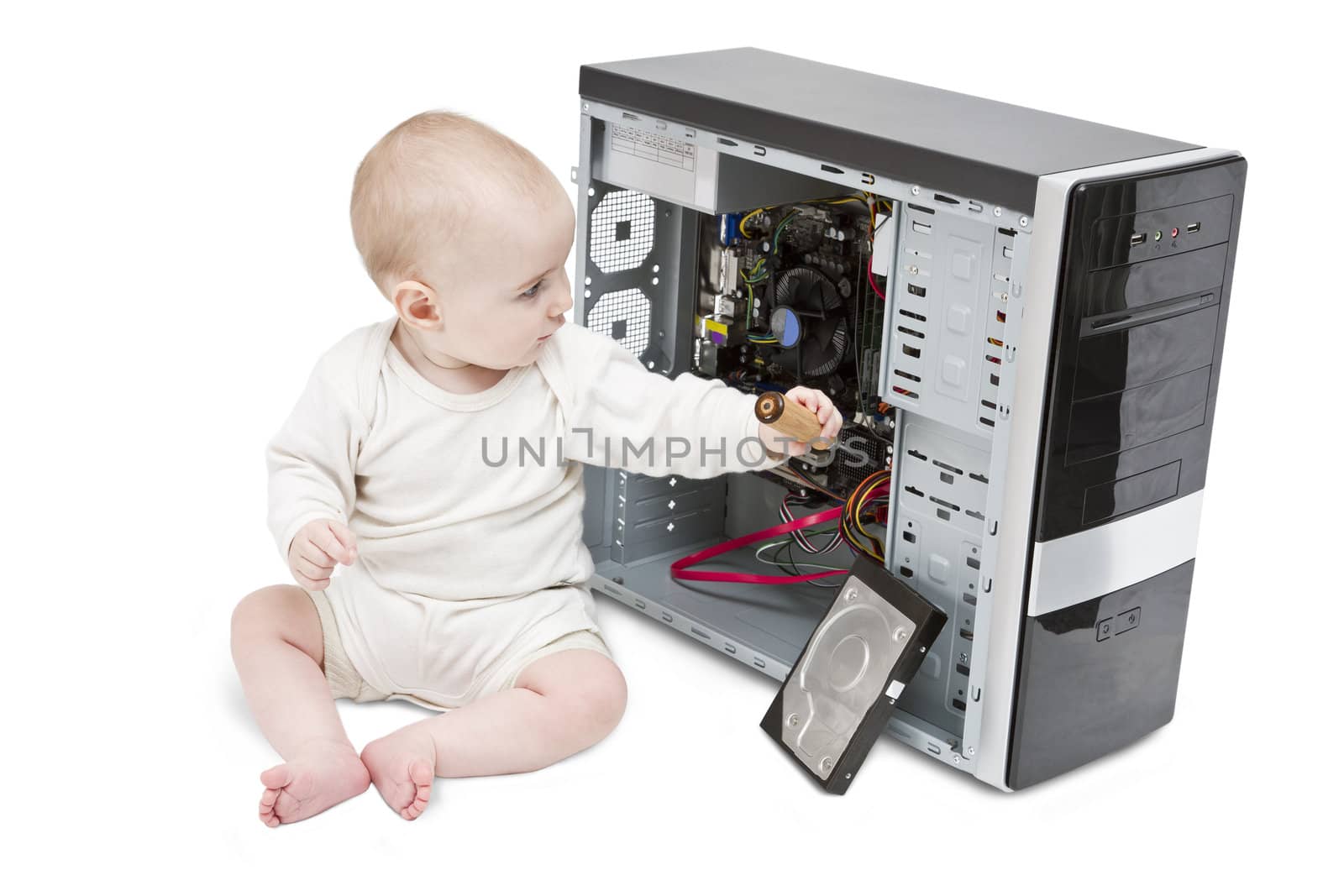 young child with screwdriver in hand working on open computer in white background.