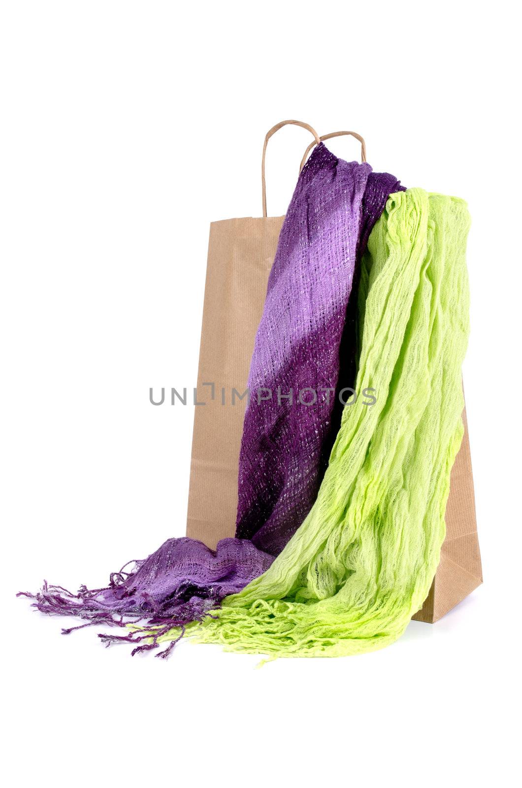 Shopping brown craft paper bag with two scarves on white background.