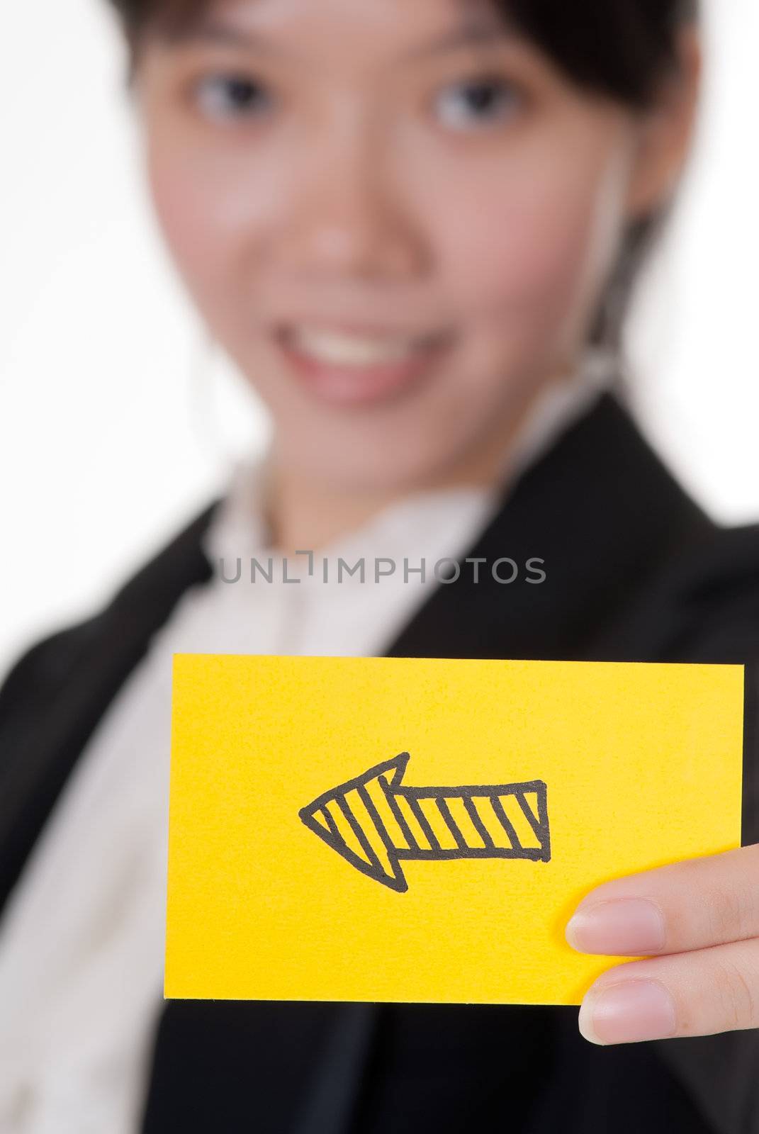 Left arrow on business card holding by Asian businesswoman.