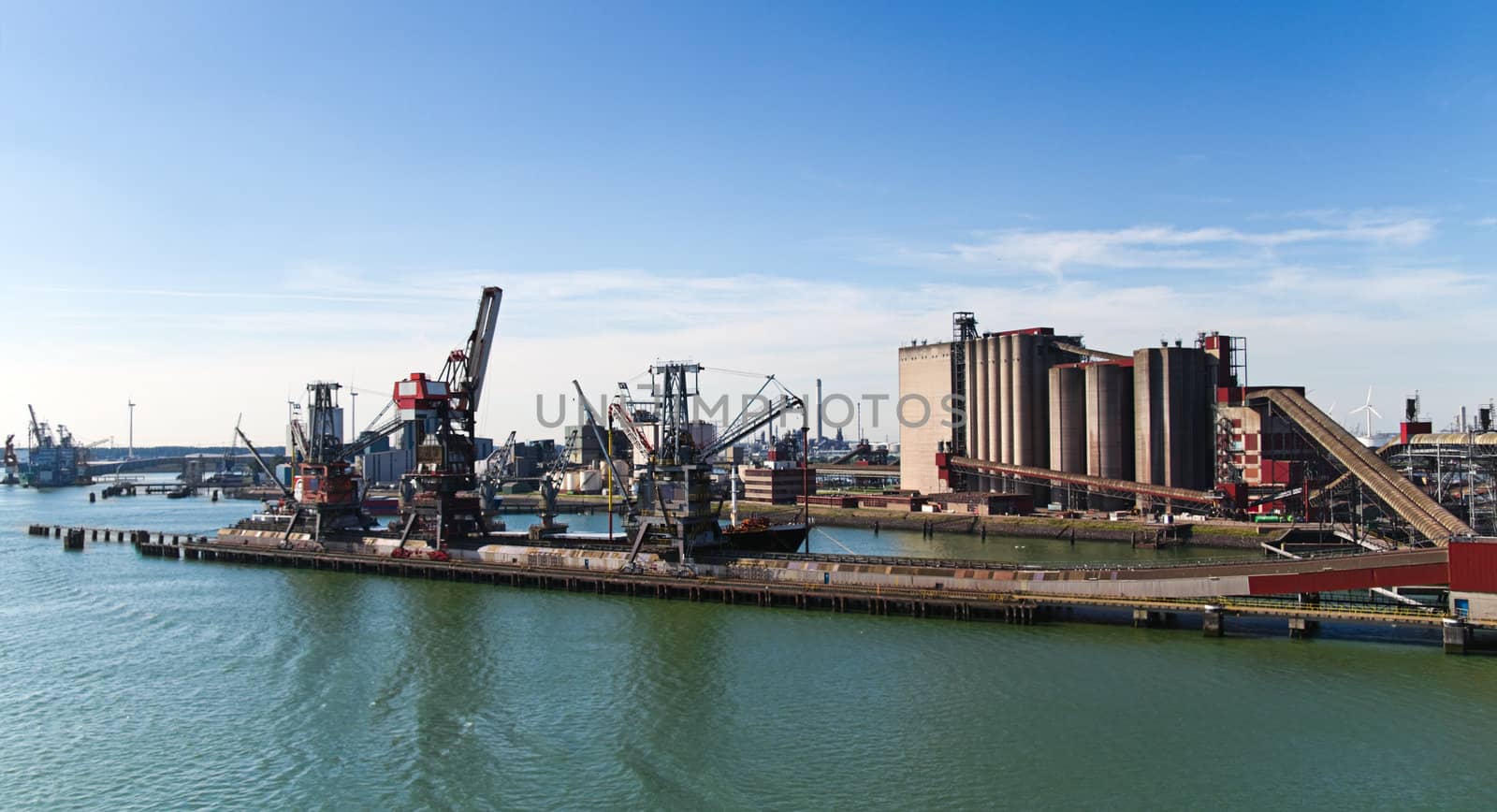 Grain elevator in harbour with terminal and cranes by Colette