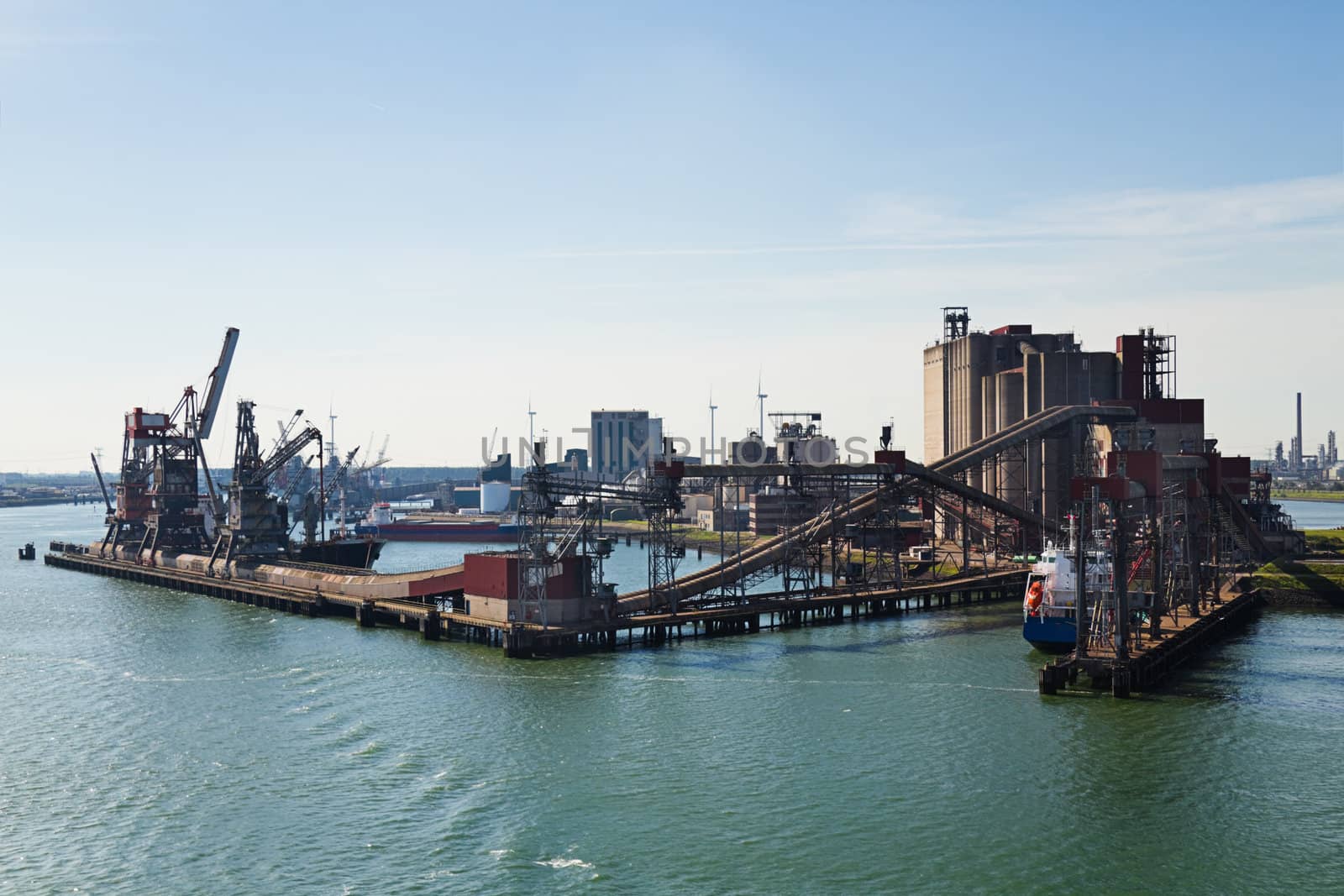 Grain elevator in harbour with terminal and cranes by Colette