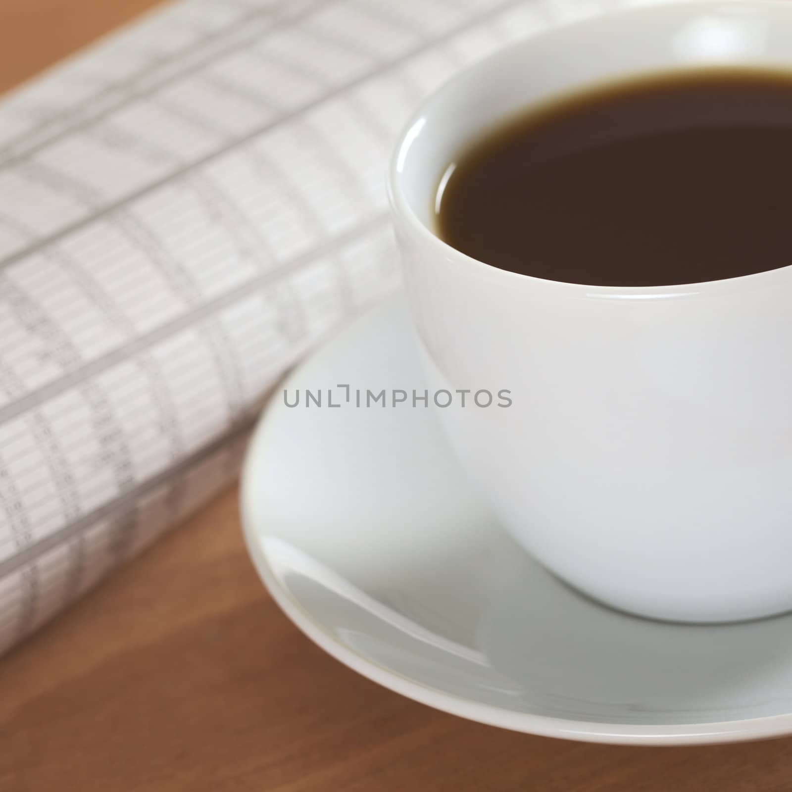 Simple hot coffee with newspaper concept (Selective Focus, Focus on the front rim of the coffee cup)