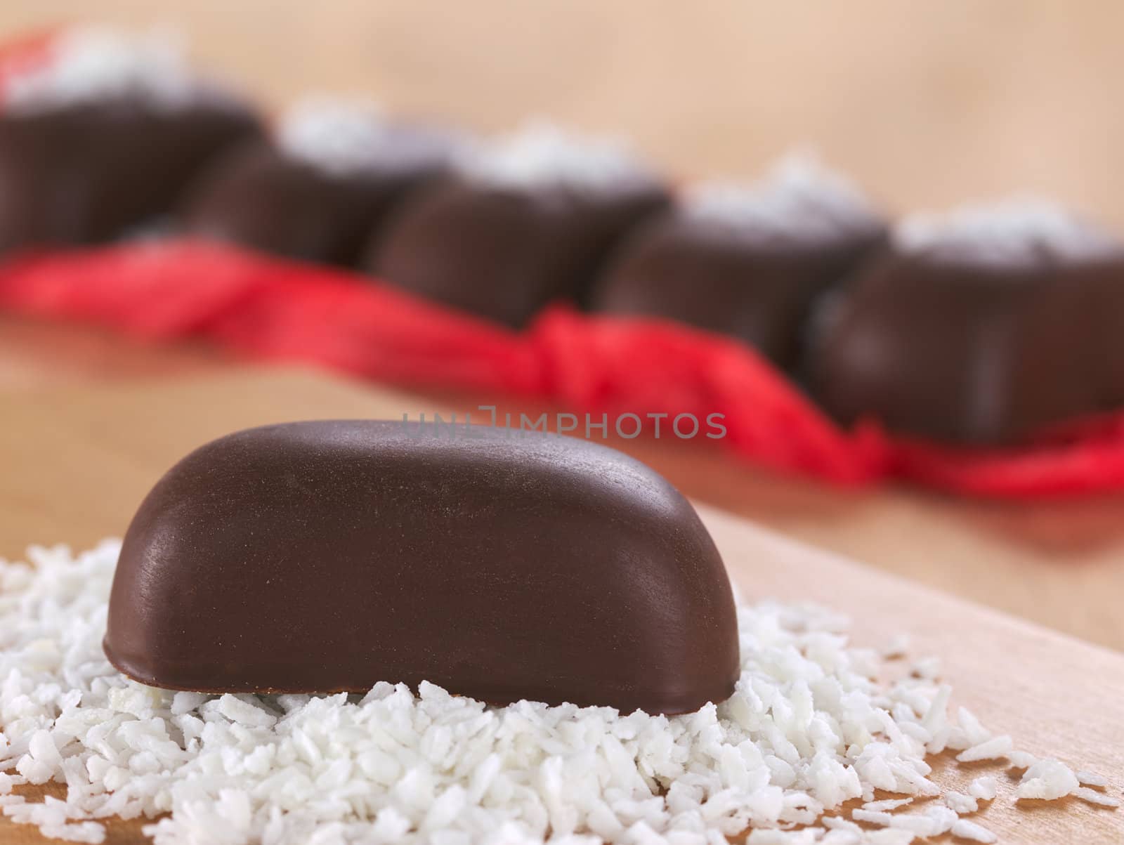 Chocolate candy on grated coconut with other chocolate candies in the back (Selective Focus, Focus on the front of the candy) 