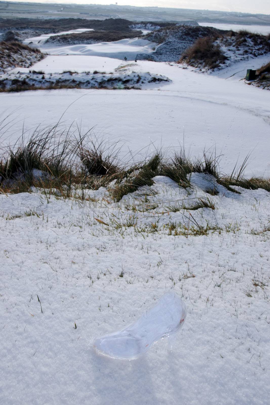 crystal glass high heels shoe on white snowy golf course by morrbyte