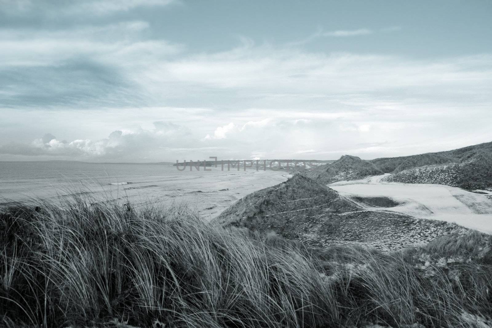 atlantic ocean beside a snow covered links golf course in ireland in snowy winter weather