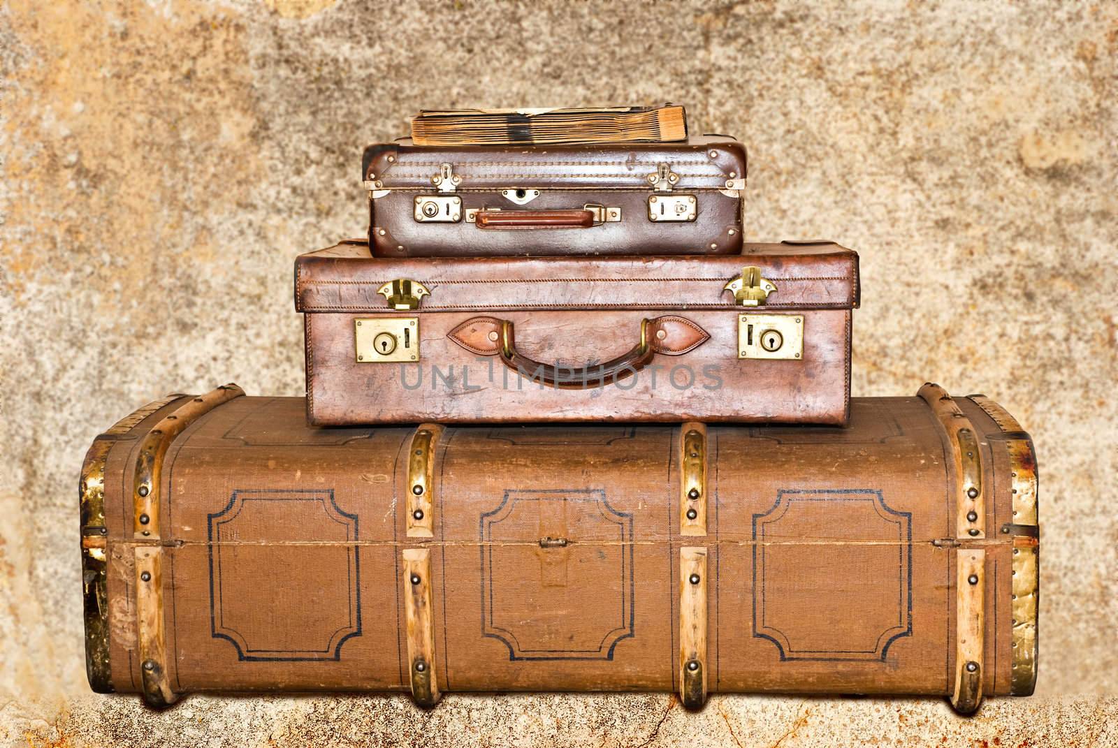 Three old leather suitcases on a grunge background