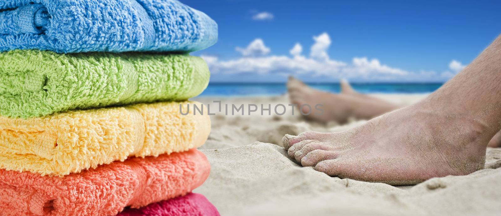 Colorful towels and bare feet on the beach