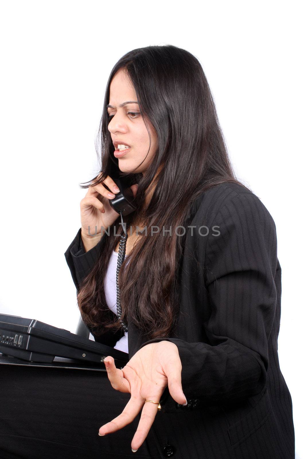 An Indian businesswoman irritated over a telephonic conversation, on white studio background.
