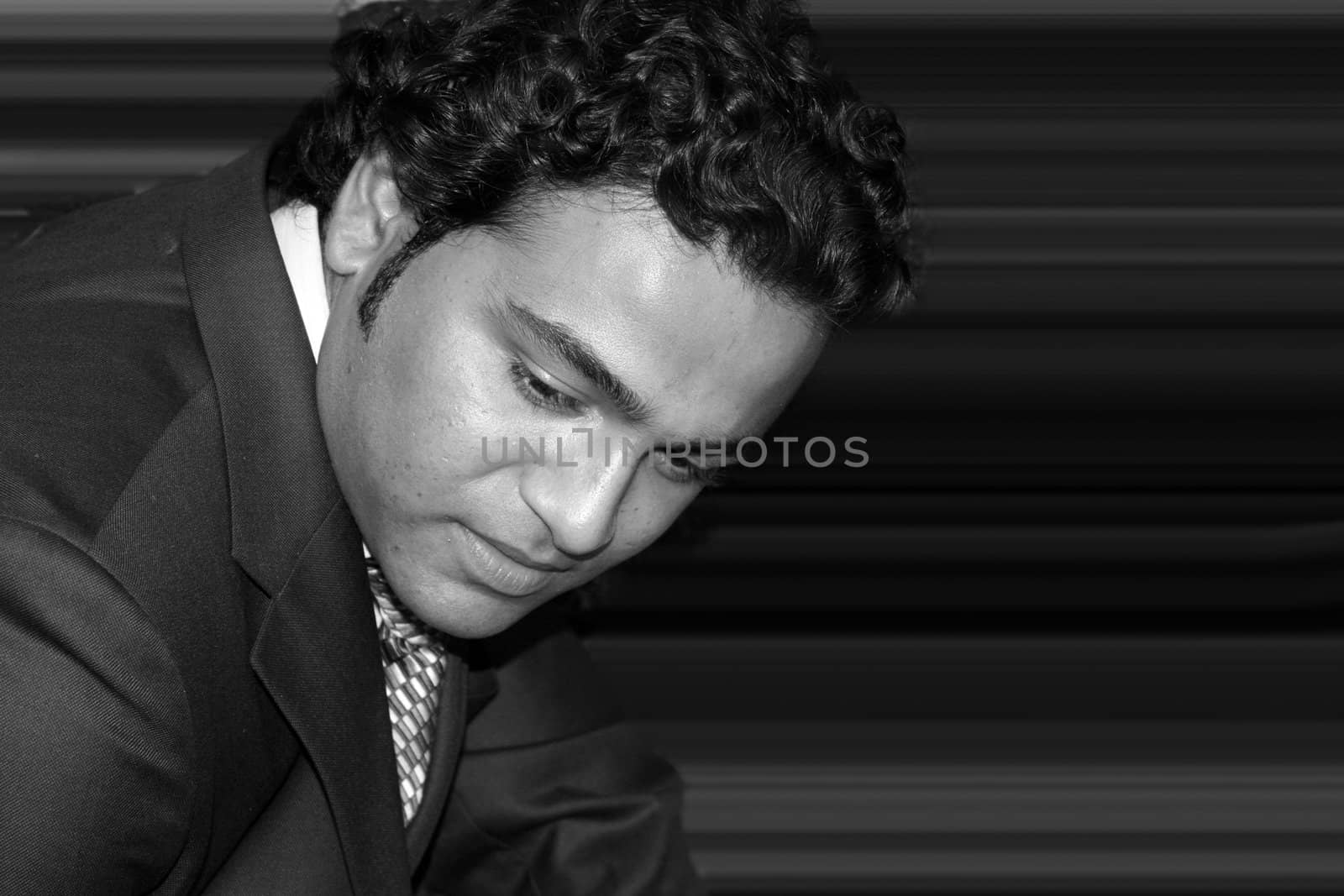 A black and white portrait of a young Indian businessman.