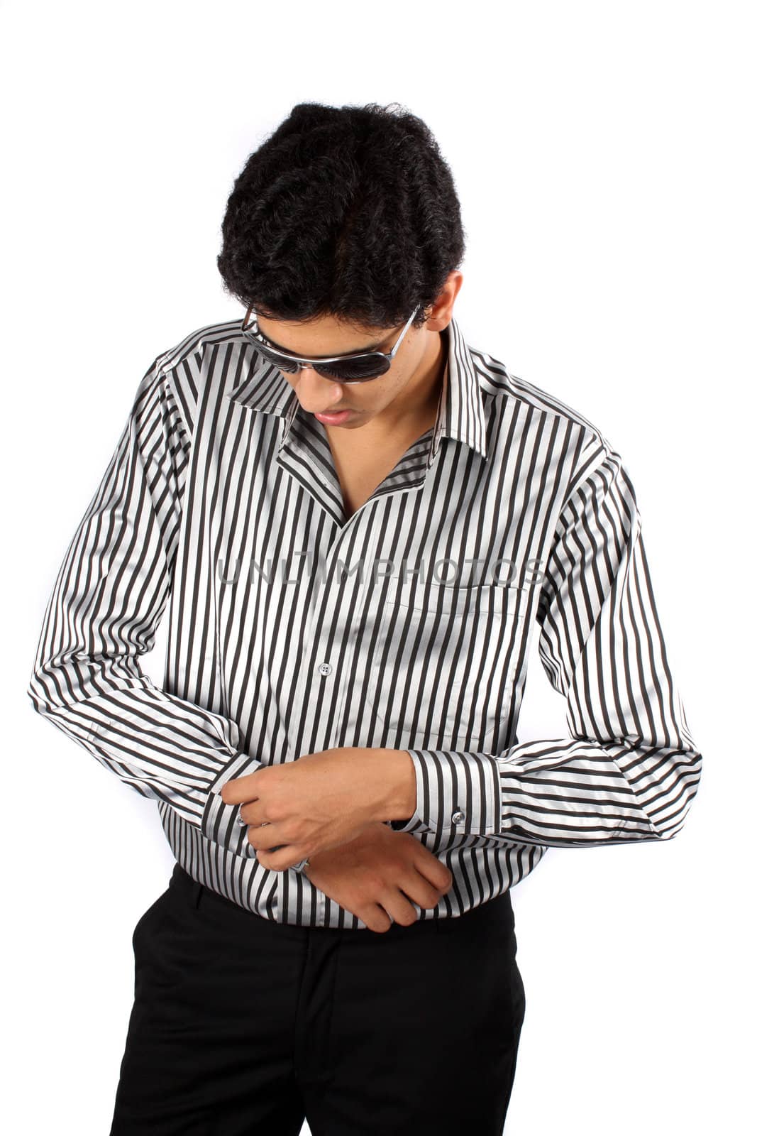 A handsome young Indian guy dressing up, on white studio background.