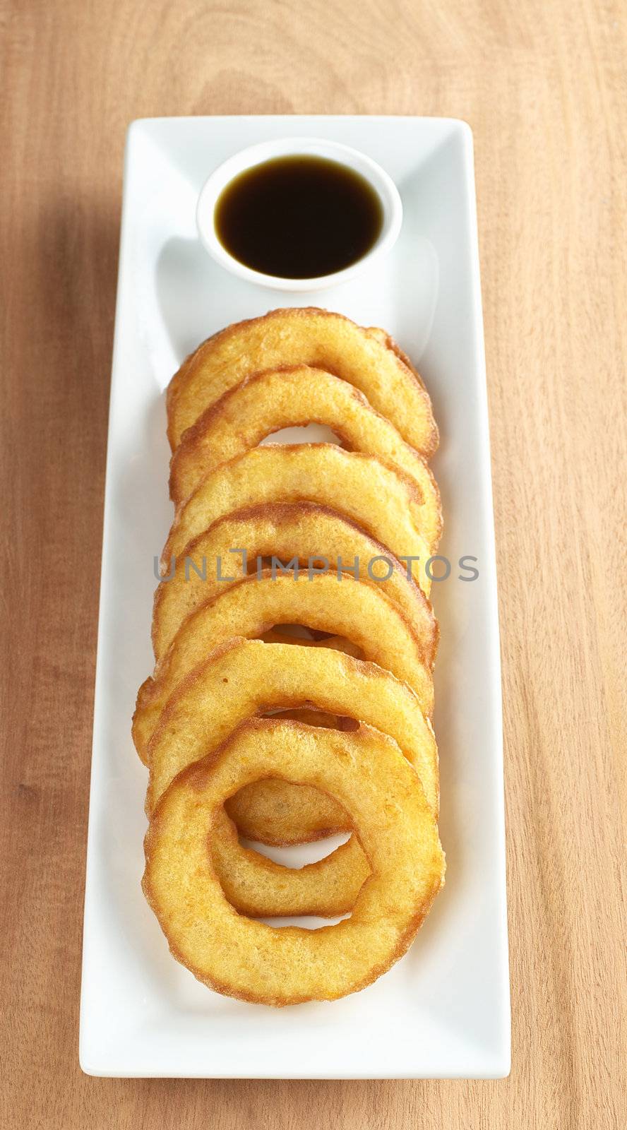 Popular Peruvian dessert called Picarones made from squash and sweet potato and served with Chancaca syrup (kind of honey), which is the black sauce (Selective Focus, Focus on the first two rings)