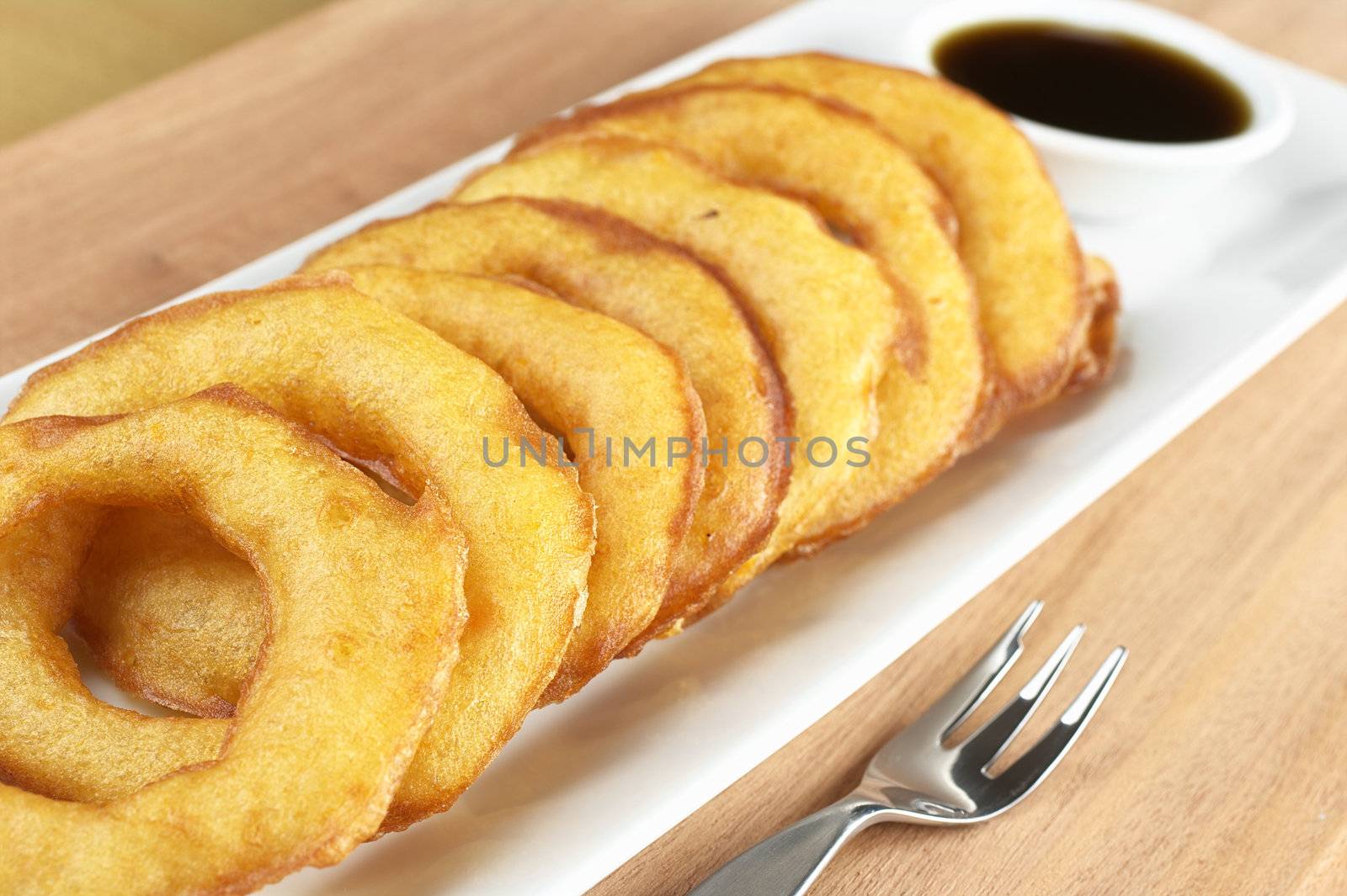 Popular Peruvian dessert called Picarones made from squash and sweet potato and served with Chancaca syrup (kind of honey), which can be seen in the back (Selective Focus, Focus on the upper right of the first ring and the right of the second)