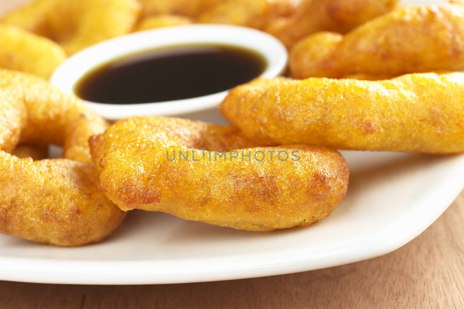 Popular Peruvian dessert called Picarones made from squash and sweet potato and served with Chancaca syrup (kind of honey) (Selective Focus, Focus on the front)