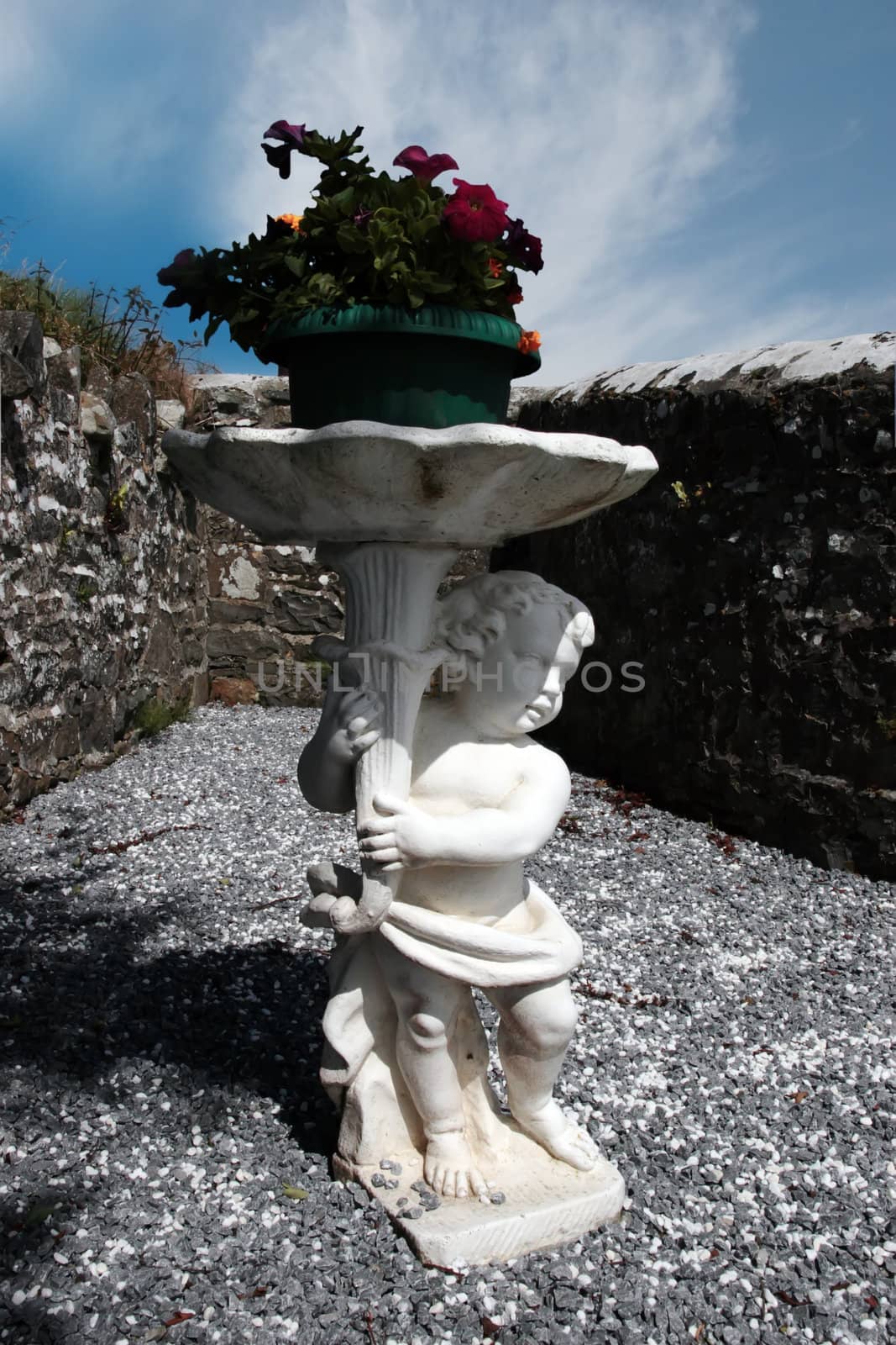 cherub statue inside the walls of a graveyard in kerry ireland