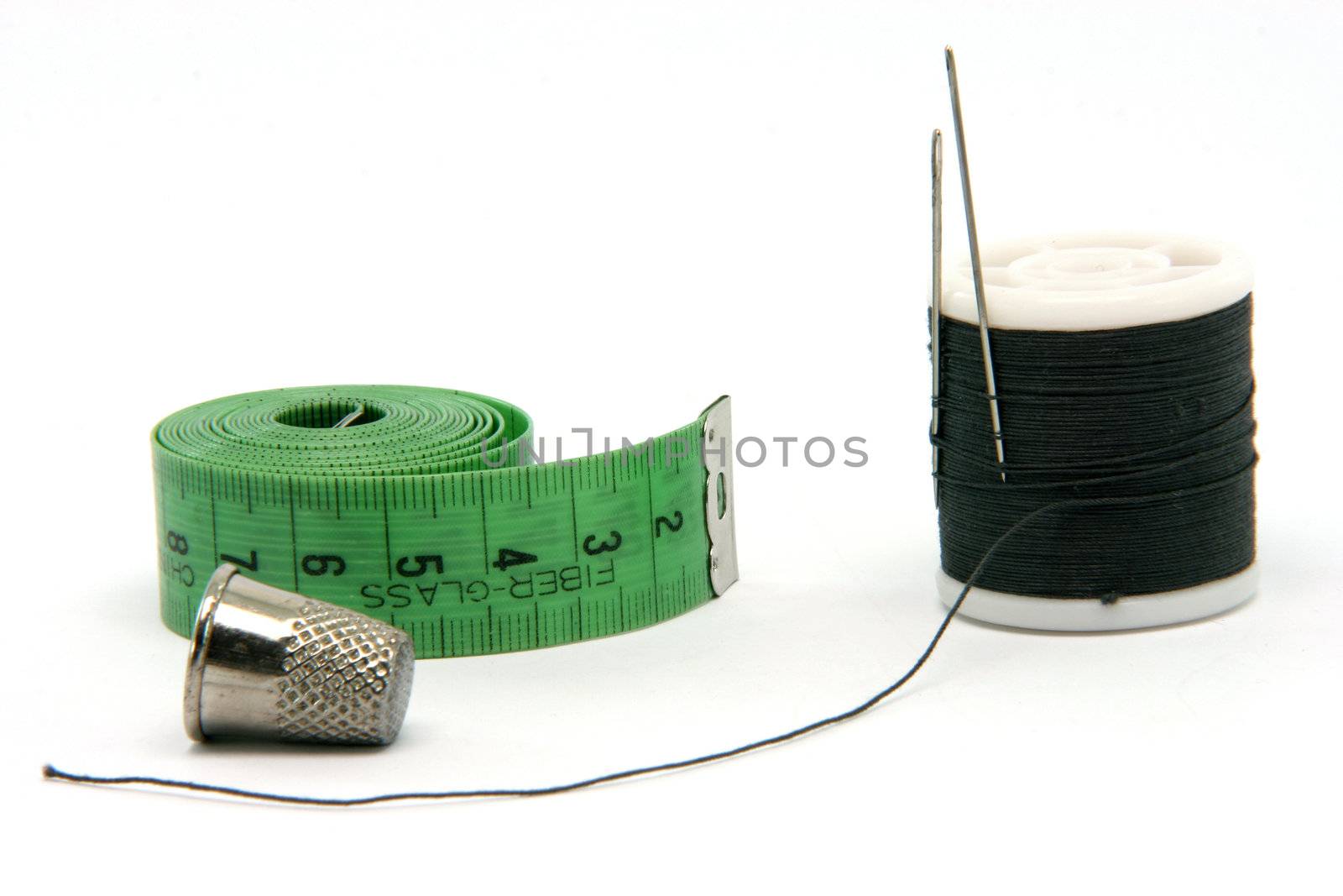 sewing items measure tape thread and thimble isolated on white background 