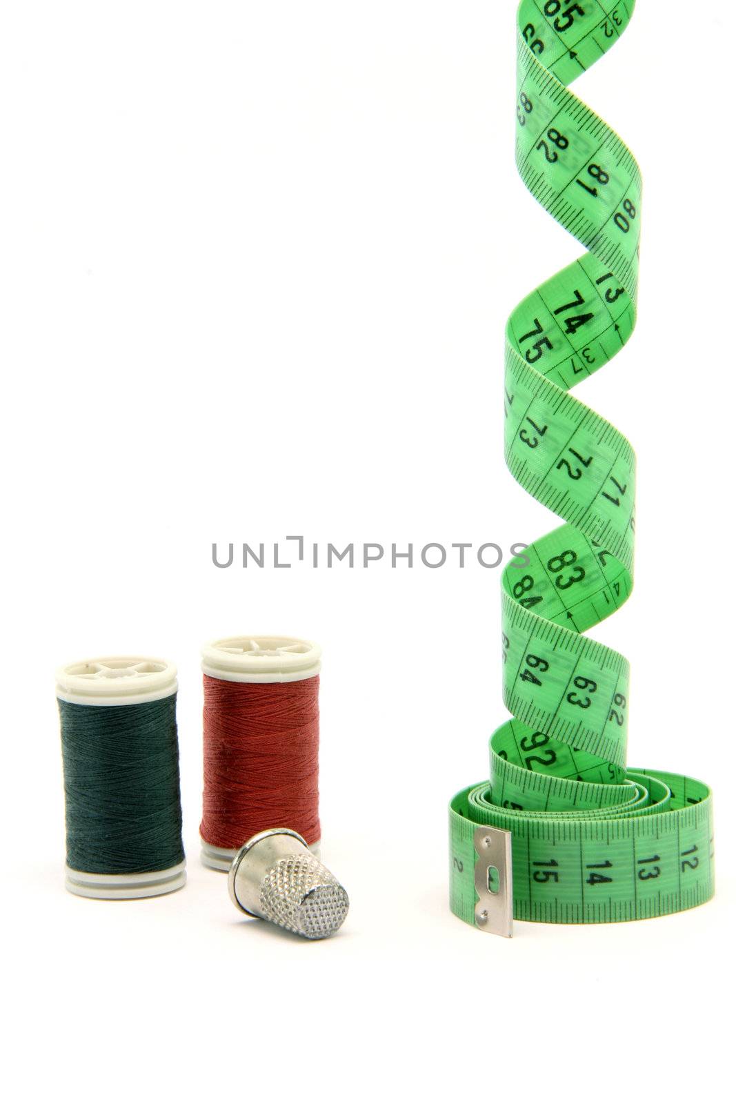 sewing items measure tape cotton strings and thimble isolated on white background vertical