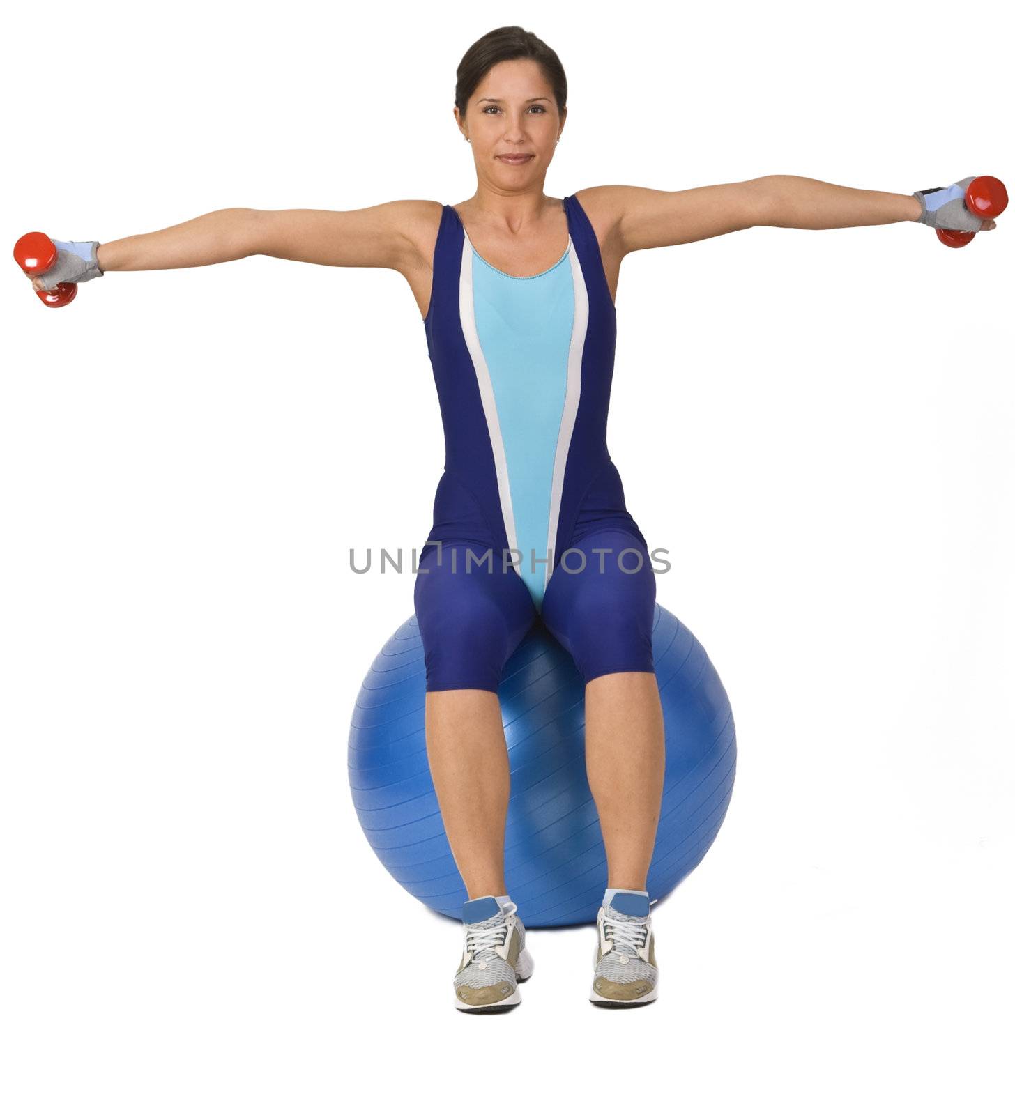 Woman doing bar-bells exercise while is sitting on a gym ball.
