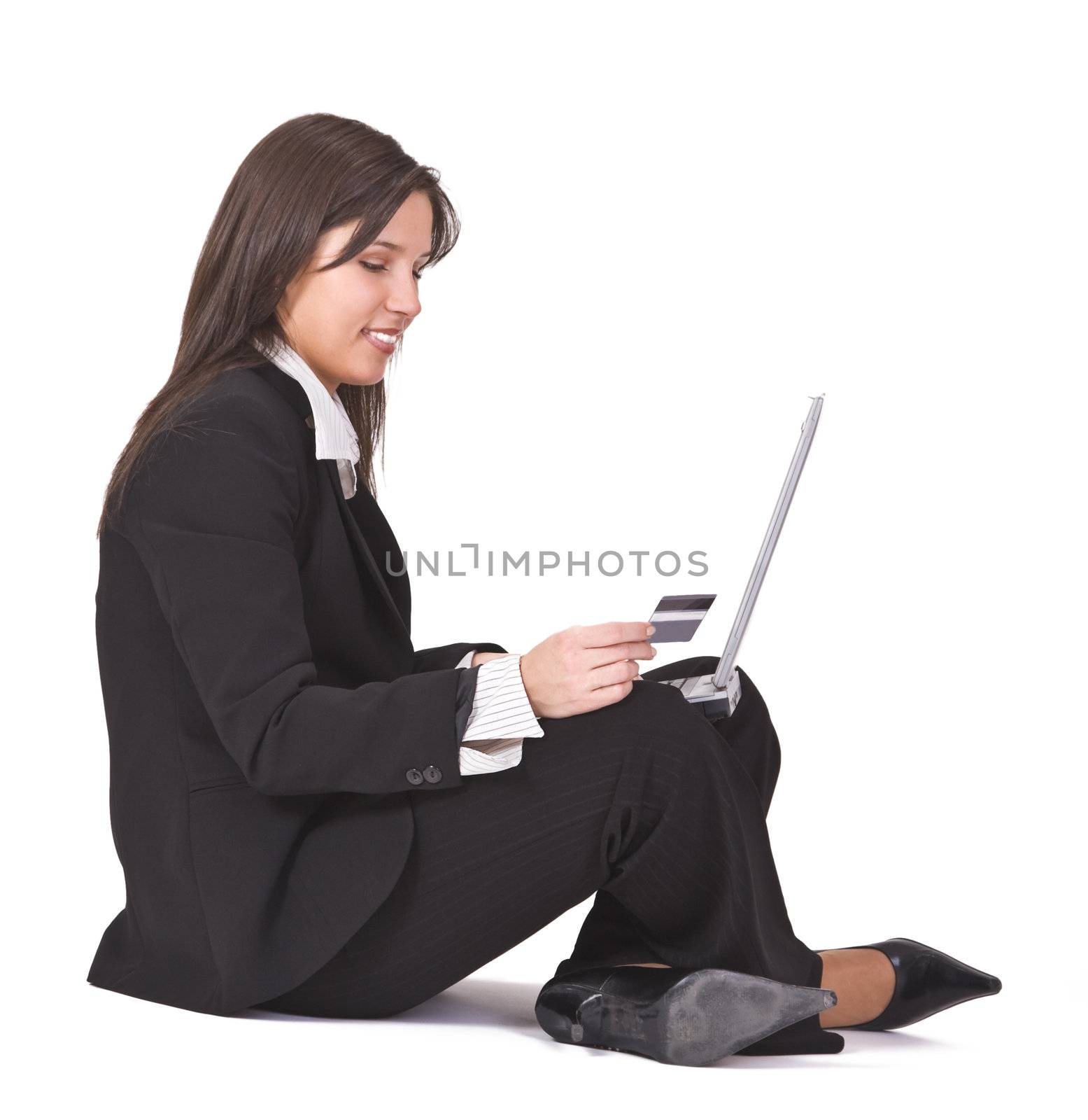 Smiling businesswoman making an online purchase by using a credit card.
