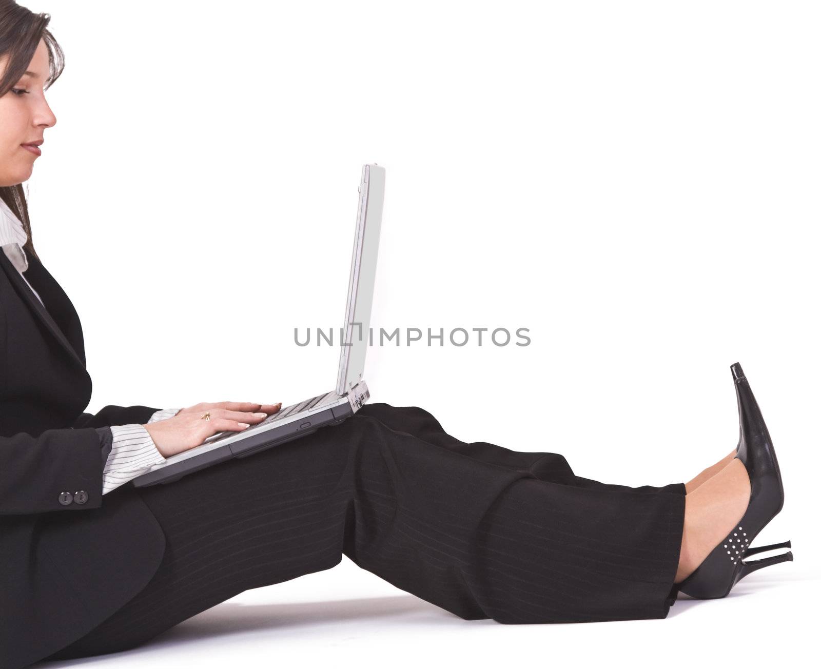 Businesswoman working on a laptop she is keeping in her lap-interesting croping