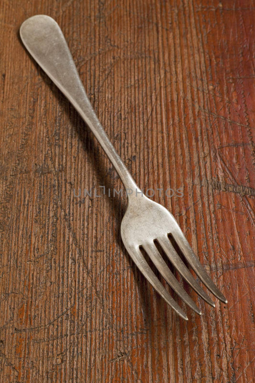 vintage fork on scratched grunge wood surface