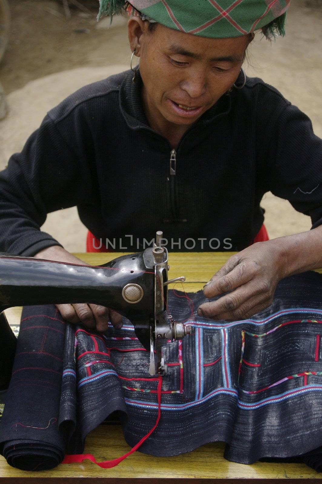 Black Hmong woman sewing machine by Duroc