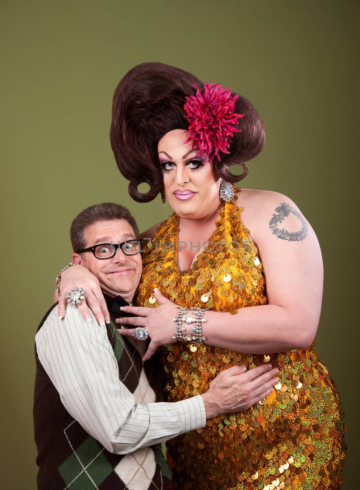 Nerd hugs a large large drag queen over a green background