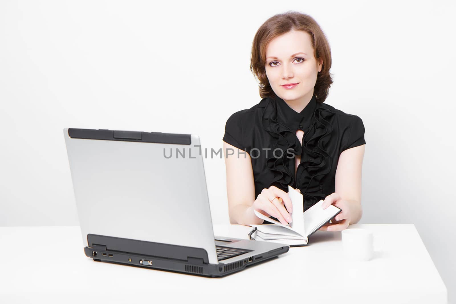 smiling slender business attractive girl with a laptop and a notebook in the office
