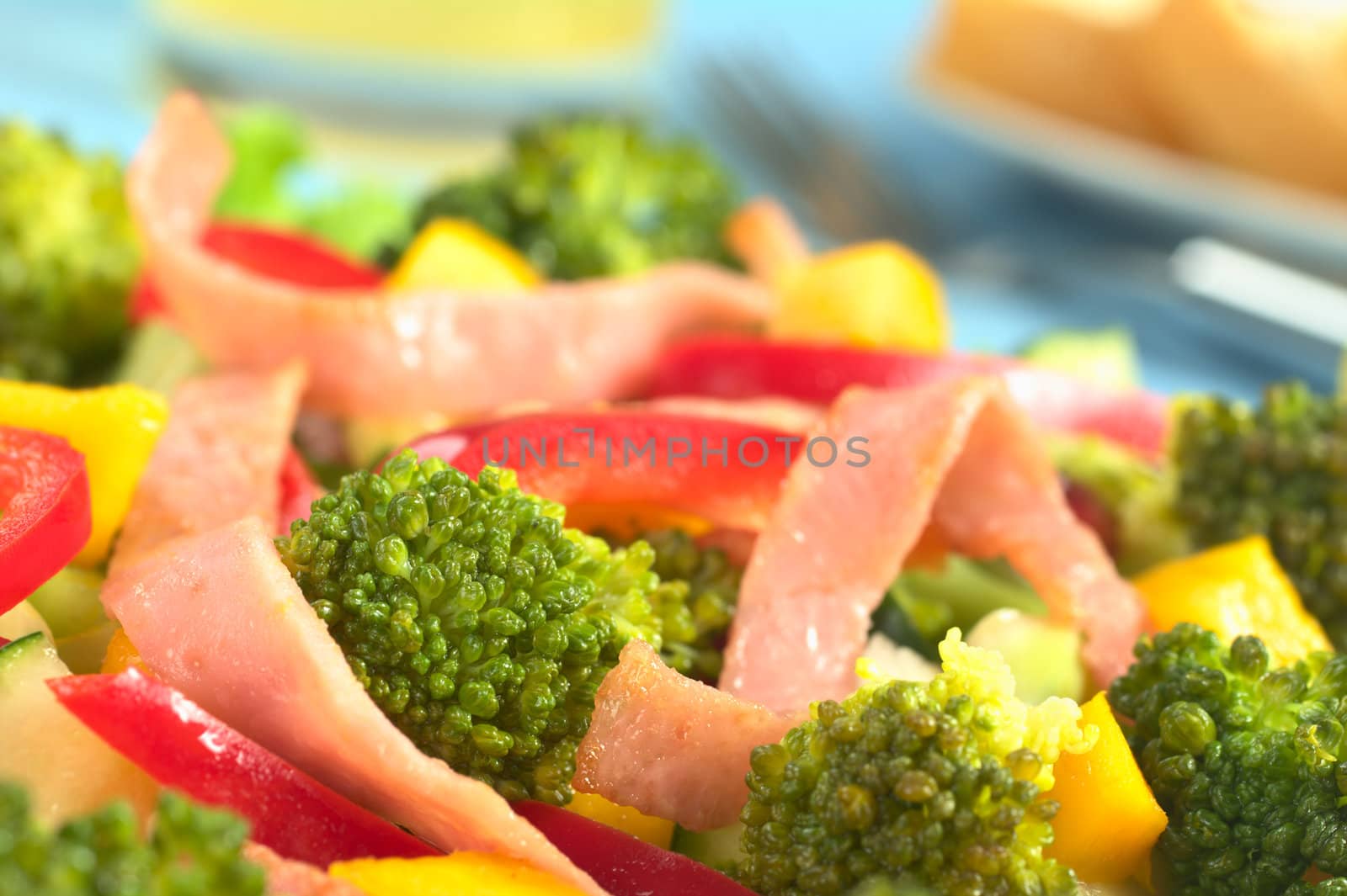 Fresh broccoli salad with red bell pepper, ham and mango (Selective Focus, Focus on the broccoli floret in the left lower part)