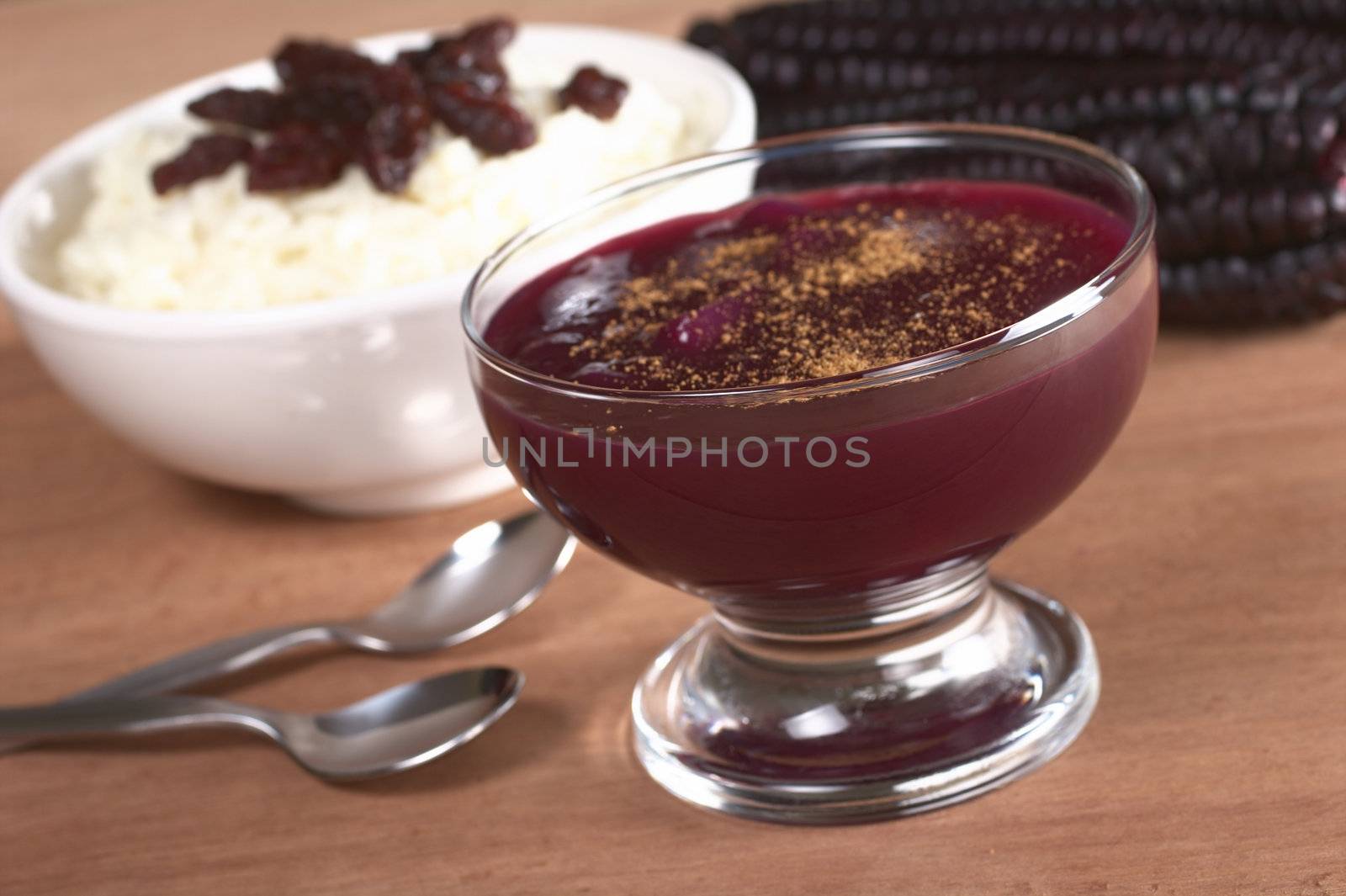 Peruvian dessert called Mazamorra Morada made out of purple corn with rice pudding in the back, which is sometimes served with it (Selective Focus, Focus on the front of the bowl)