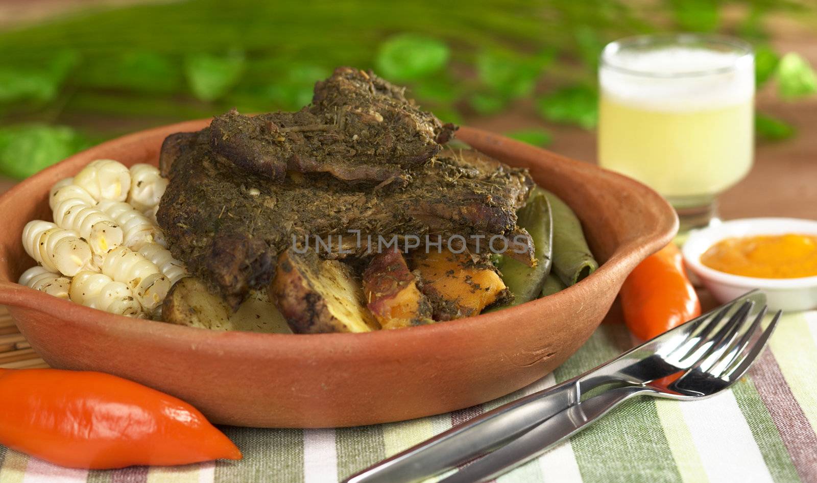 Traditional Peruvian dish called Pachamanca from the Andean regions. Its main ingredients are different meat, herbs, potatoes, broad beans (Spanish: habas), sweet potatoes and corn (Selective Focus, Focus on the meat) 