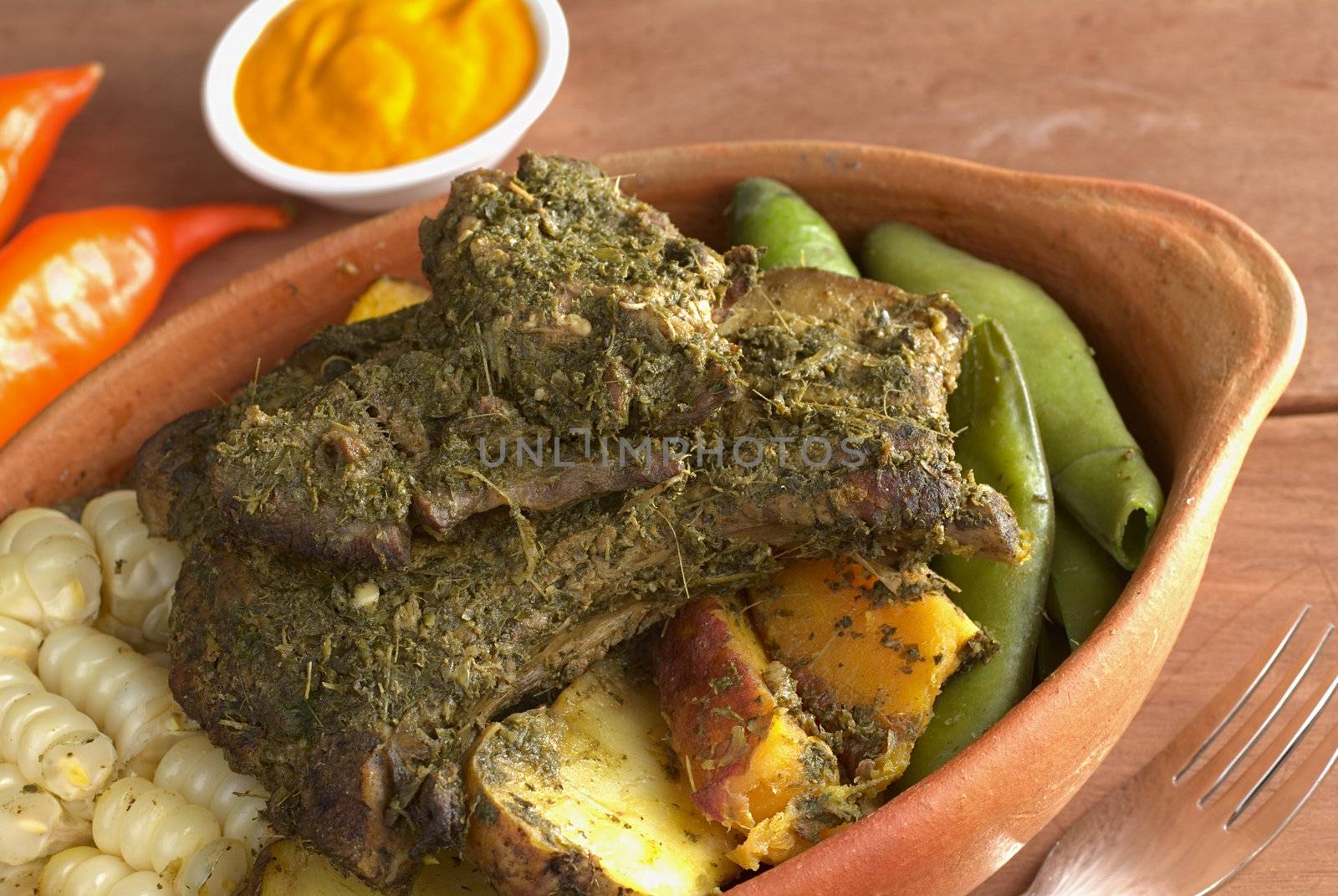 Traditional Peruvian dish called Pachamanca from the Andean regions. Its main ingredients are different kinds of meat, herbs, potatoes, broad beans (Spanish: habas), sweet potatoes and corn. It is served with hot pepper called aji (Selective Focus, Focus on the meat) 