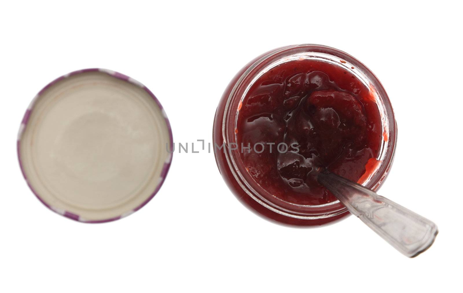 Upper view of a jar of strawberry jam with spoon in it, isolated against a white background. 