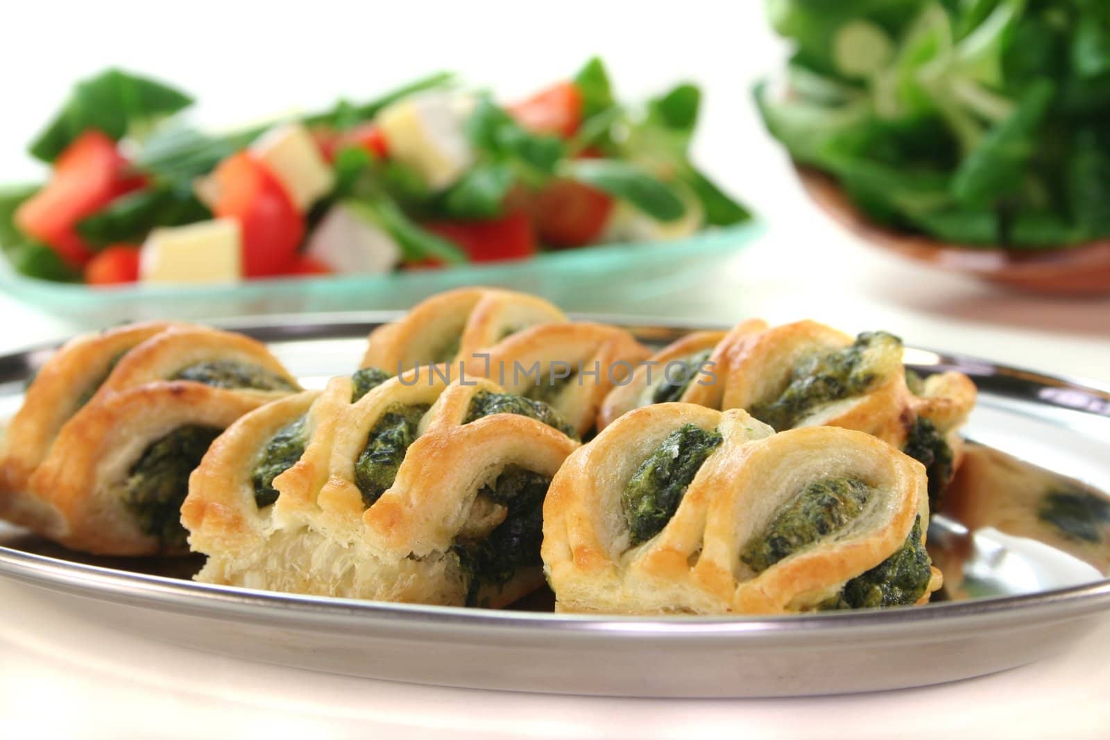 Puff pastry with spinach and cheese filling on a silver tray