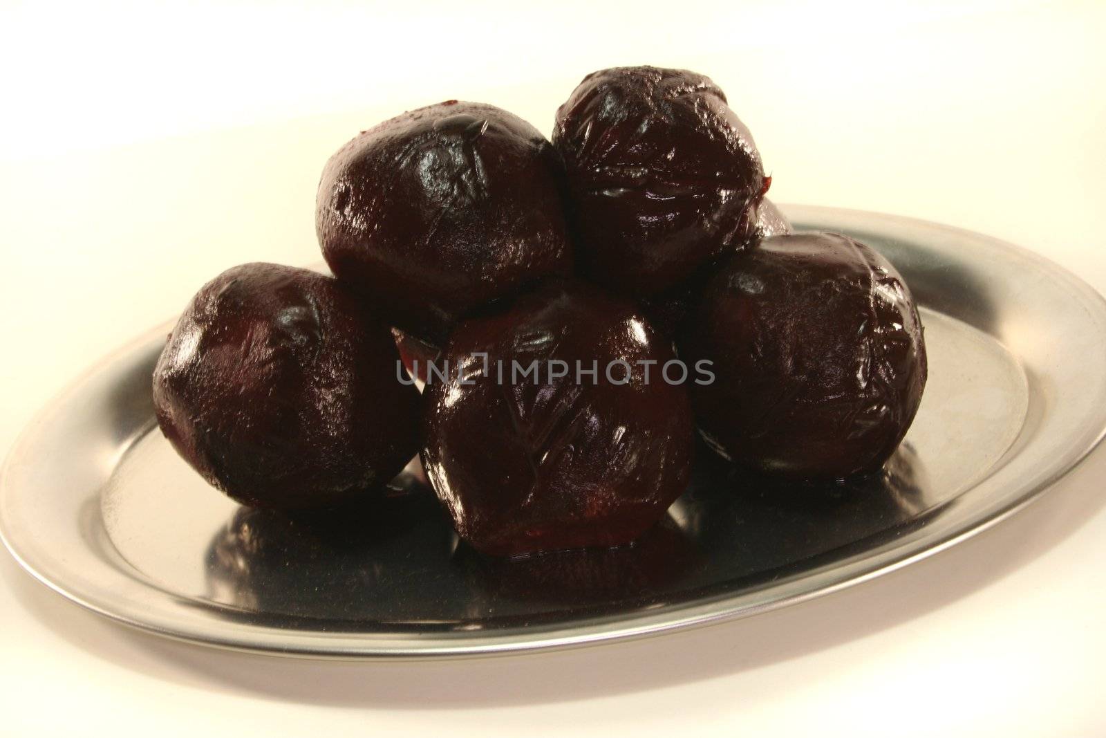 beetroot balls on a silver platter before a white background