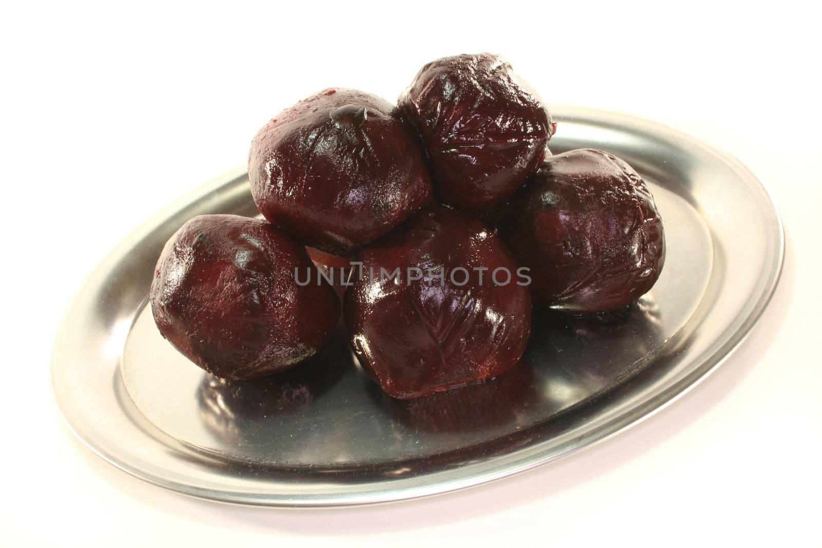 beetroot balls on a silver platter before white background