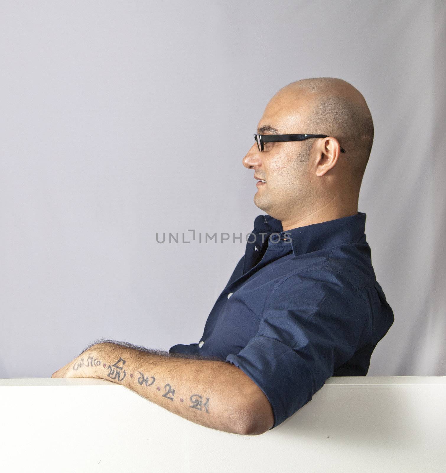 man sat at an open window, side elevation wearing glasses