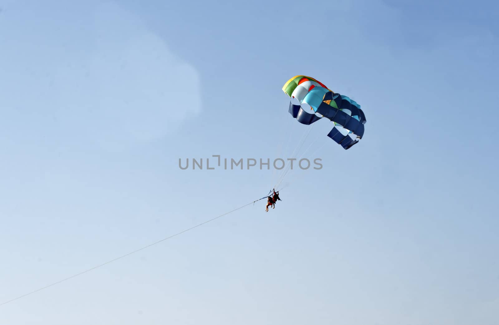 para sailers beach sports Calangute Goa India through blue sky wispy clouds