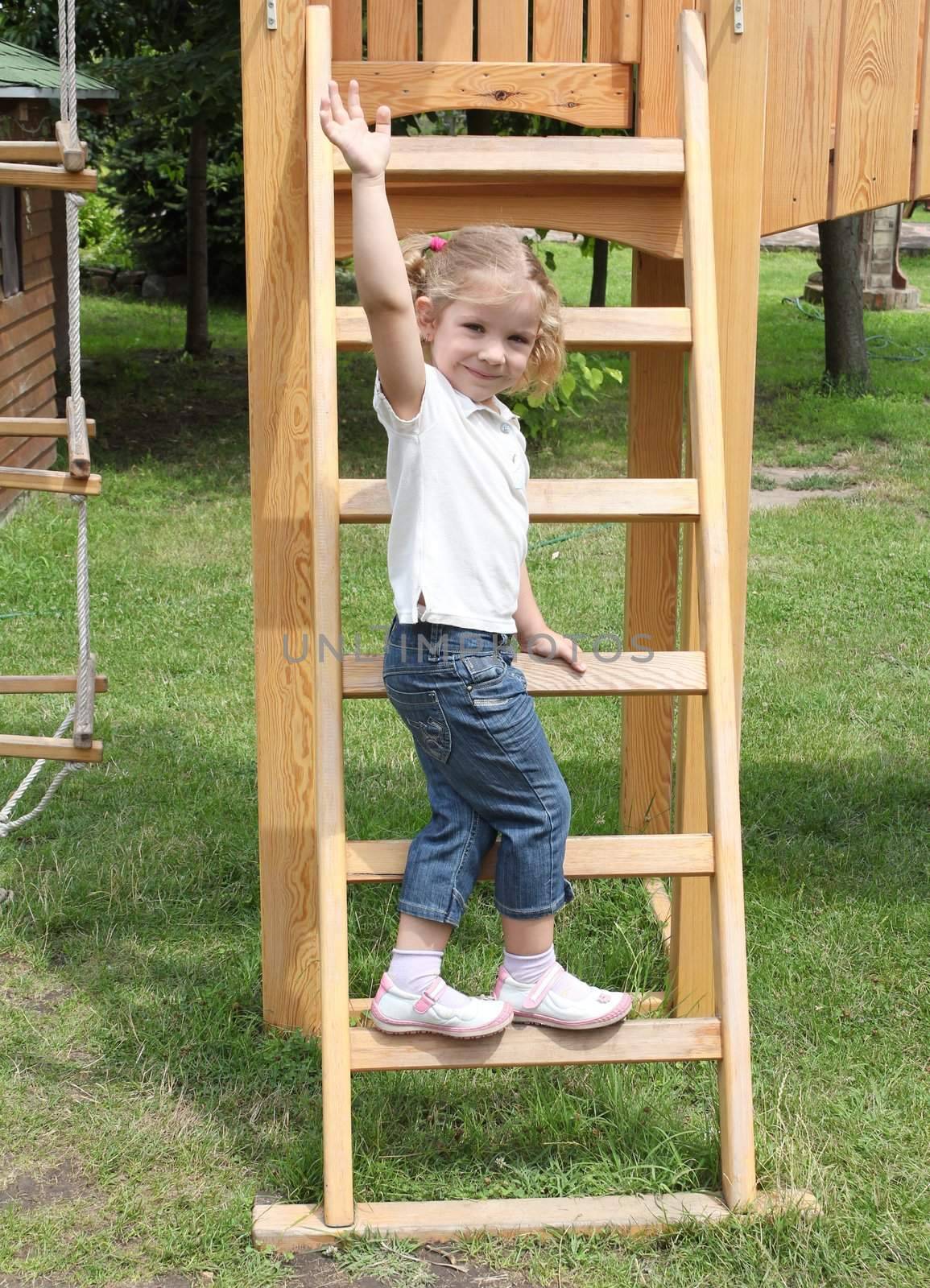 happy little girl standing on ladder