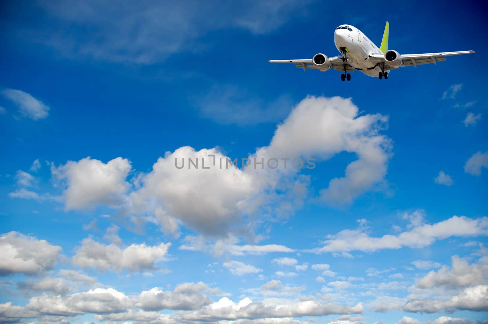 Air travel - Plane flying in blue and cloudy sky.