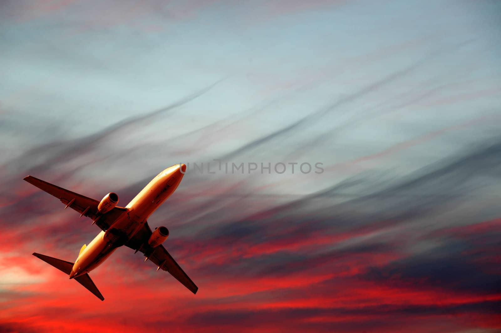 Plane is flying while the sun is setting
