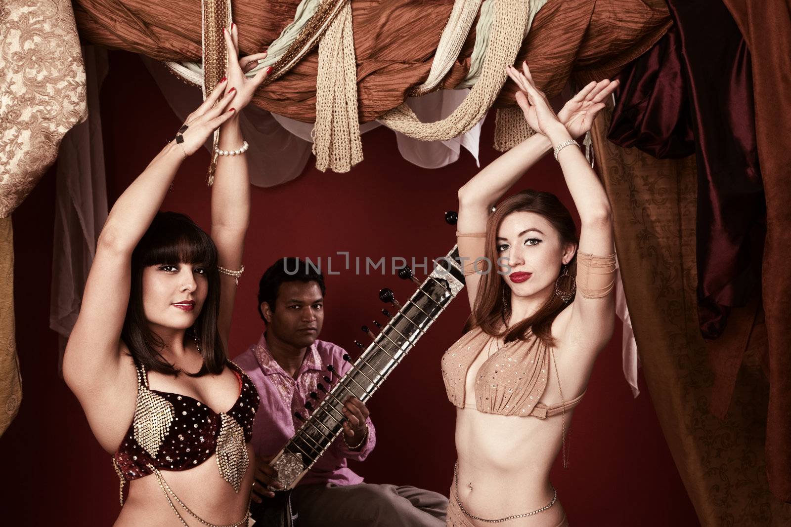 Two beautiful Arab belly dancers with Indian man playing Sitar