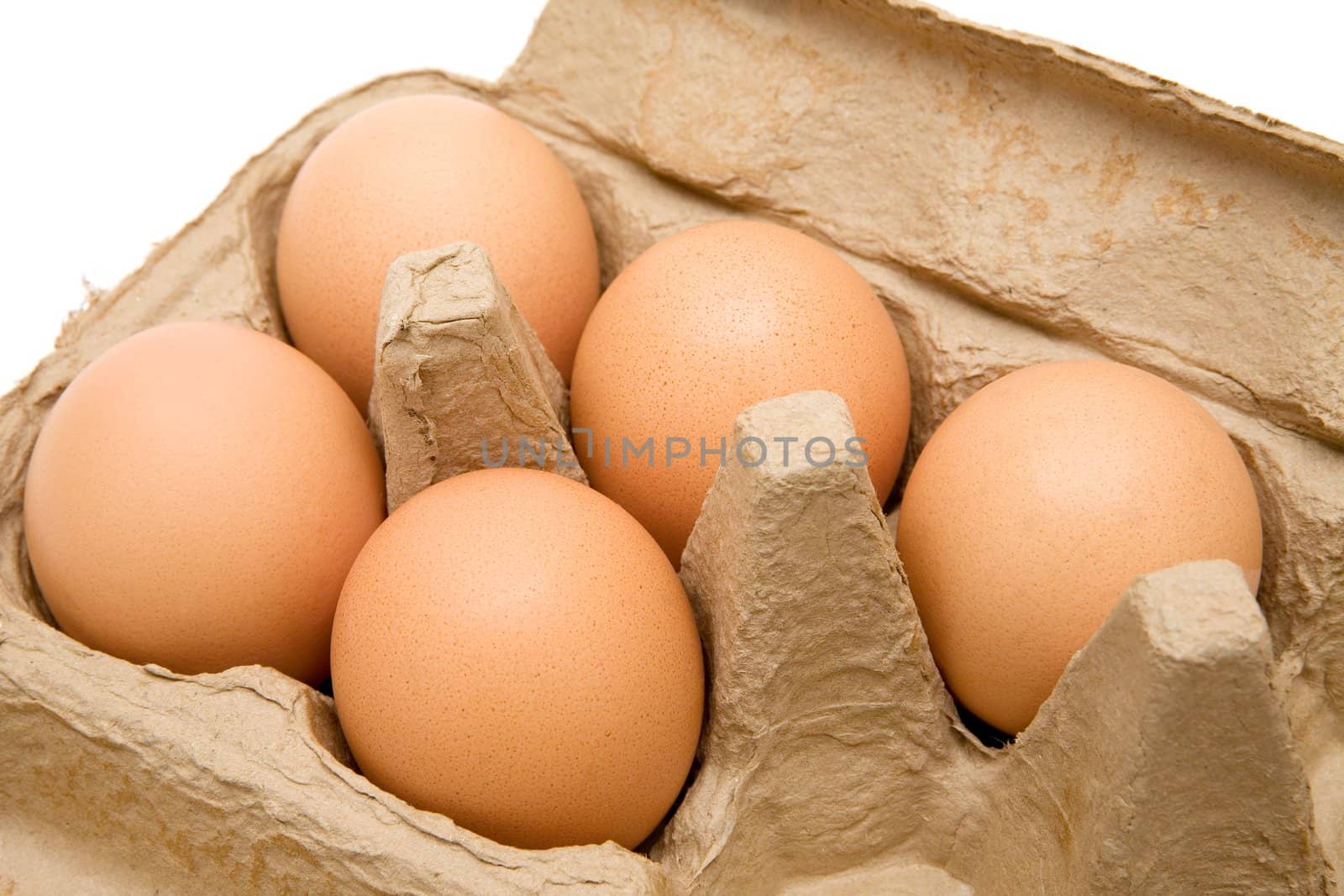 Five brown eggs in a carton. White background.