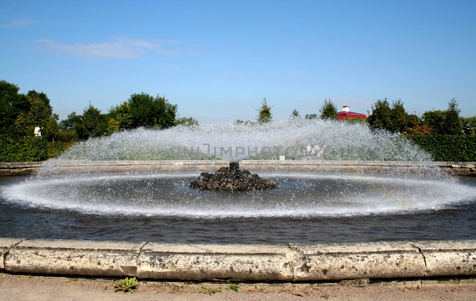 fountain in the garden, red roof and blue sky

