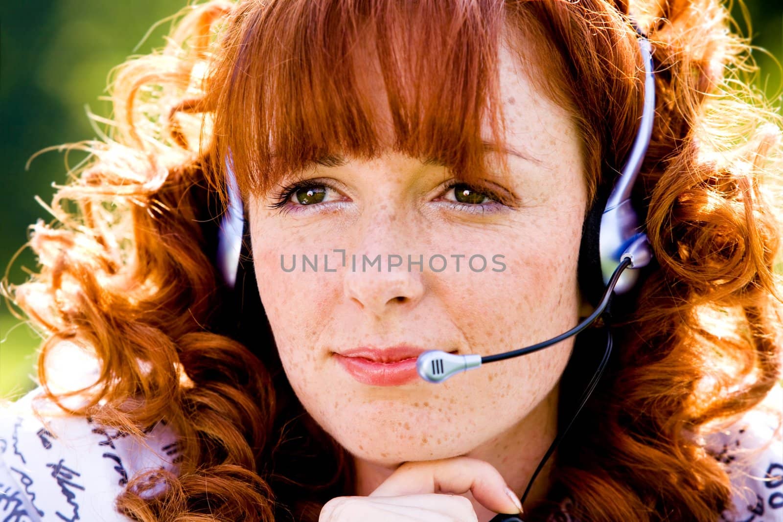 Close-up portrait of red-haired lovely young woman with headset outdoors