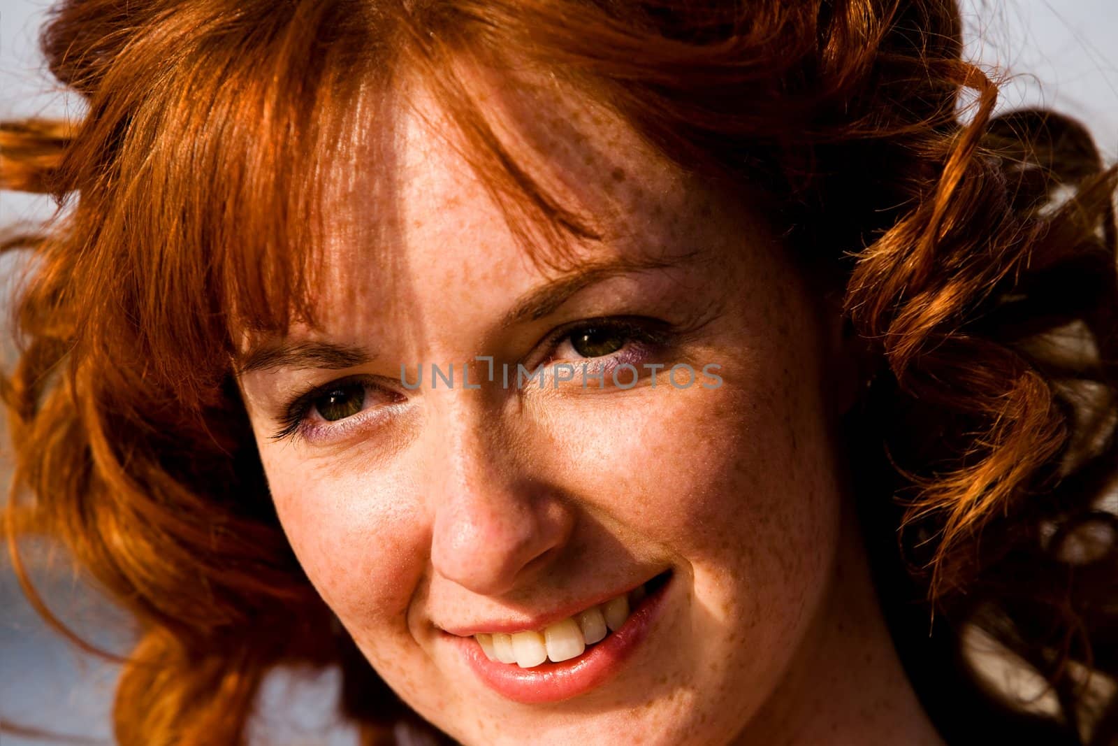 Close-up bright portrait of red-haired lovely young woman outdoors