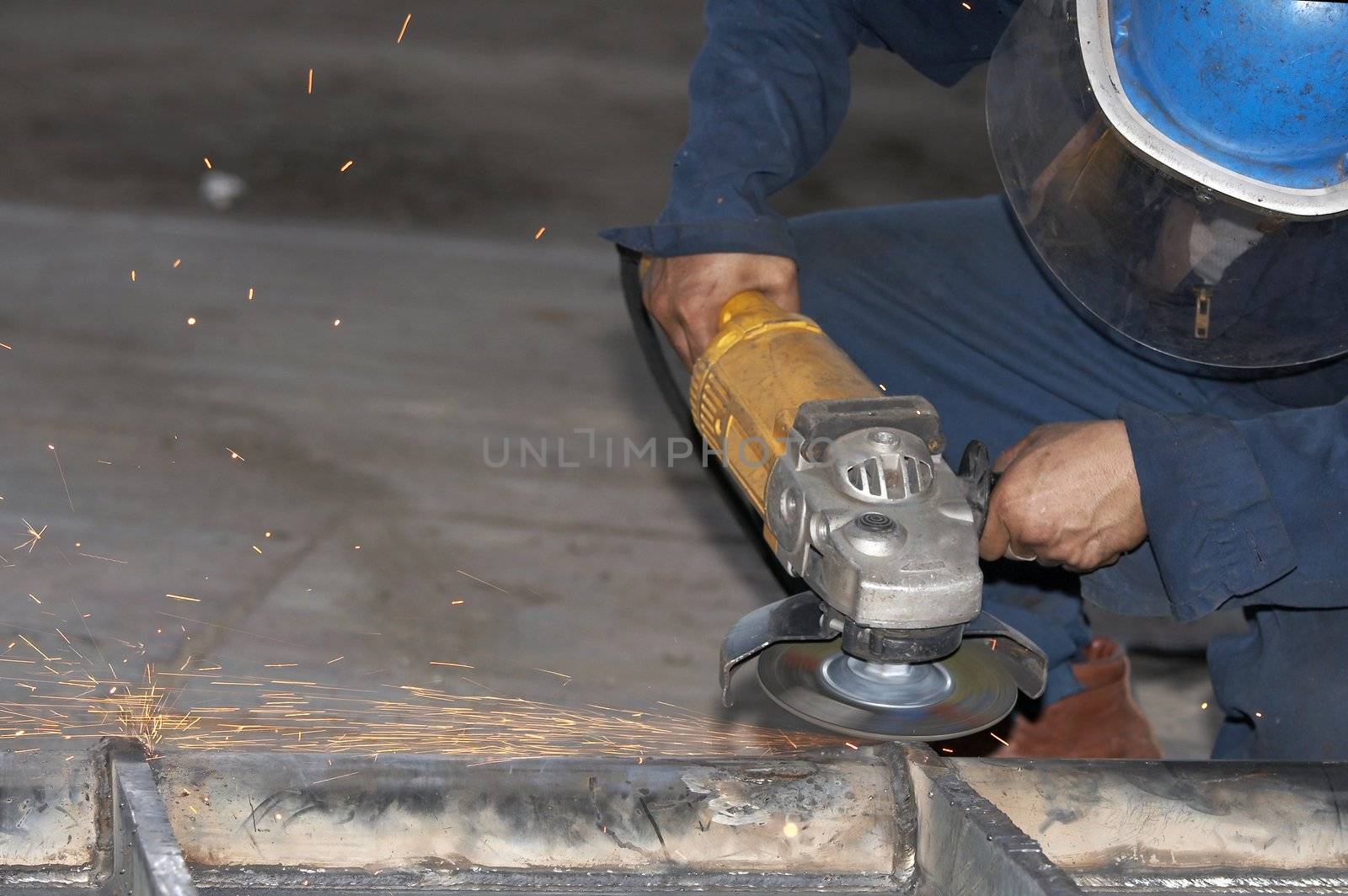 a picture of a worker grinding steel