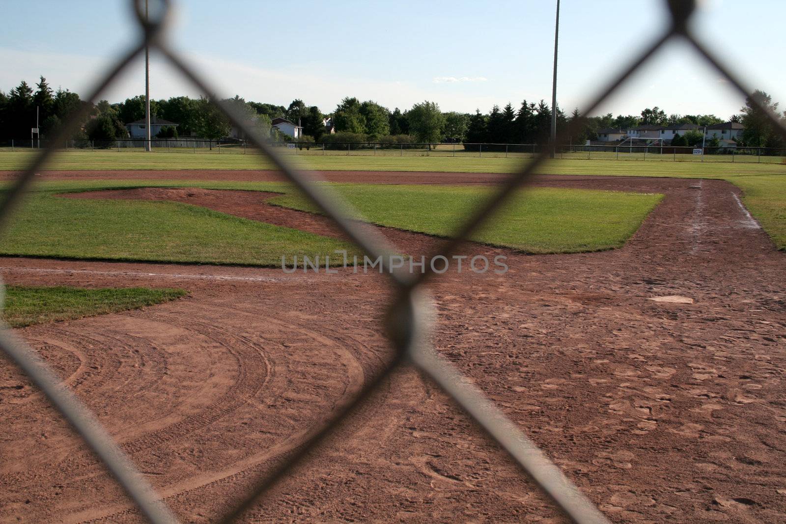 The view of a ball diamond from behind the fench.