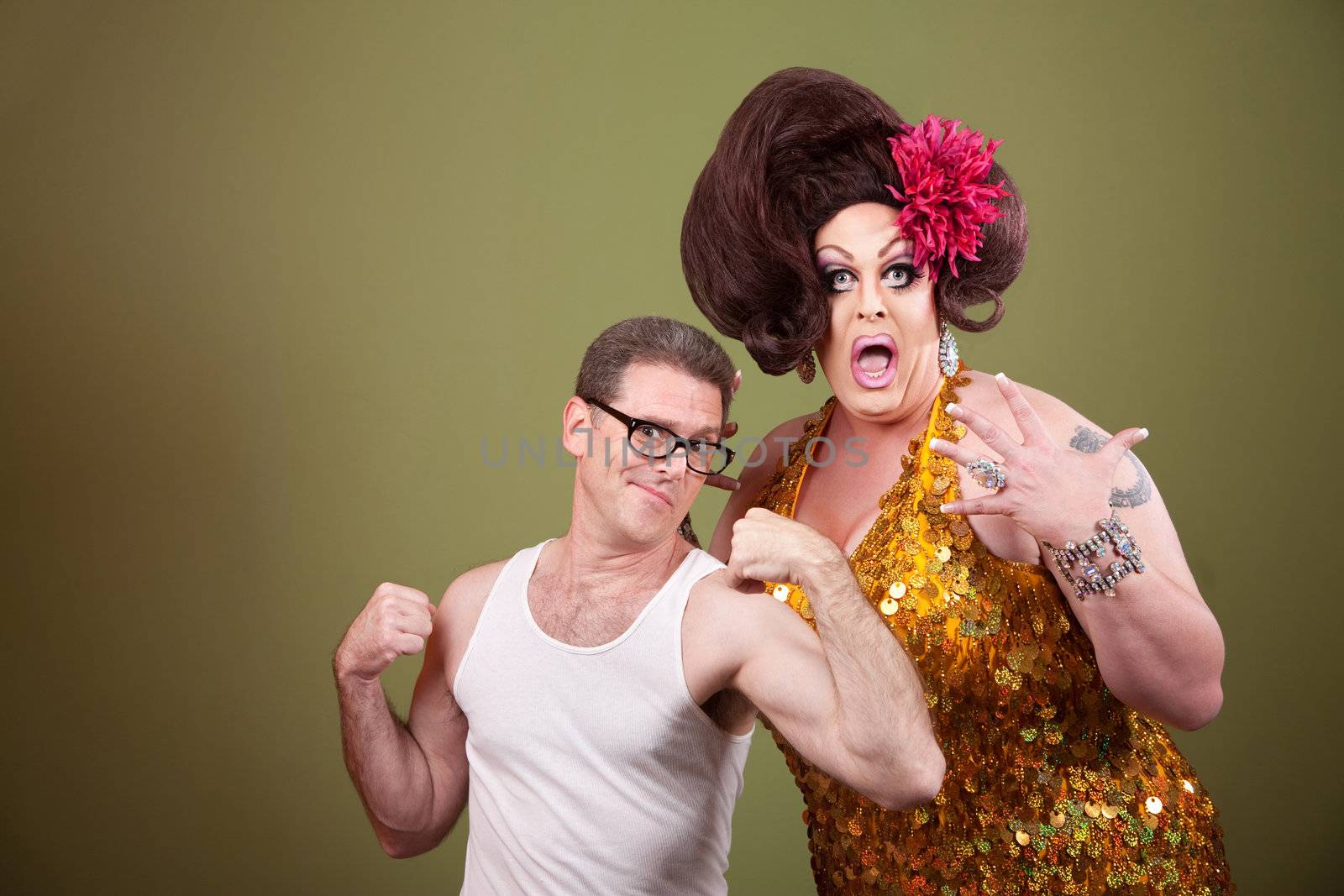 Shocked tall drag queen with short muscular man