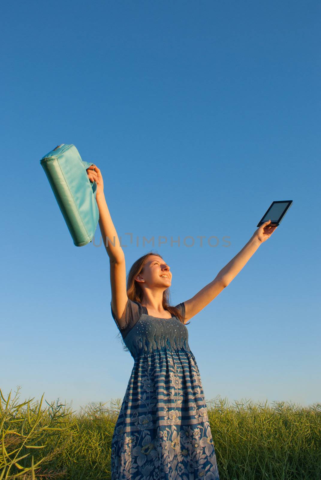 Teen girl with electronic book reader outdoors by AndreyKr